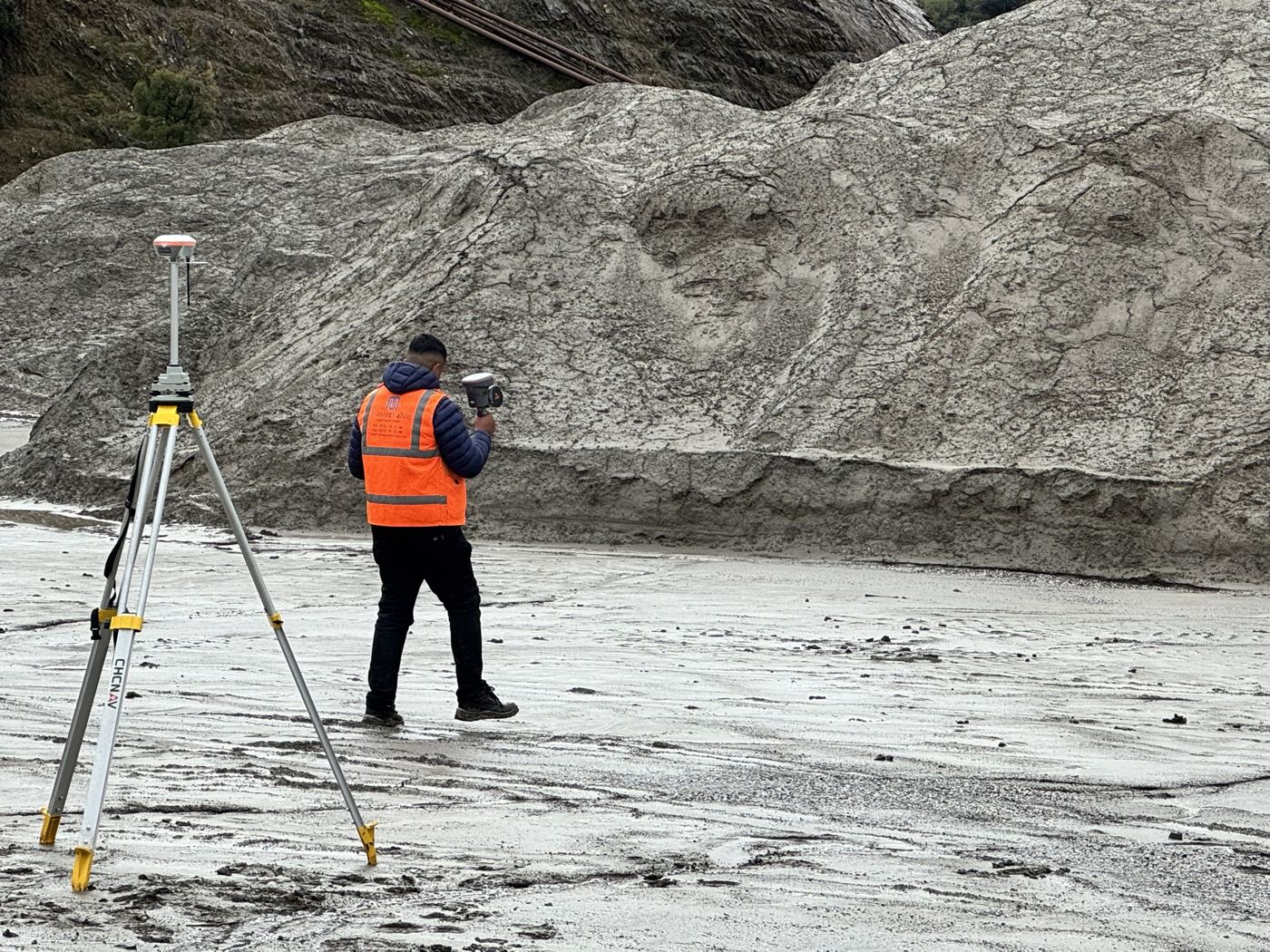 Opérateur réalisant un levé GNSS au pied d'un stock